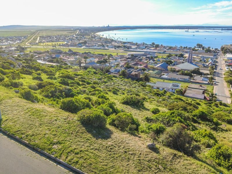 An elevated aerial view of the residential area and coastline, showcasing the surrounding landscape and proximity to the water.