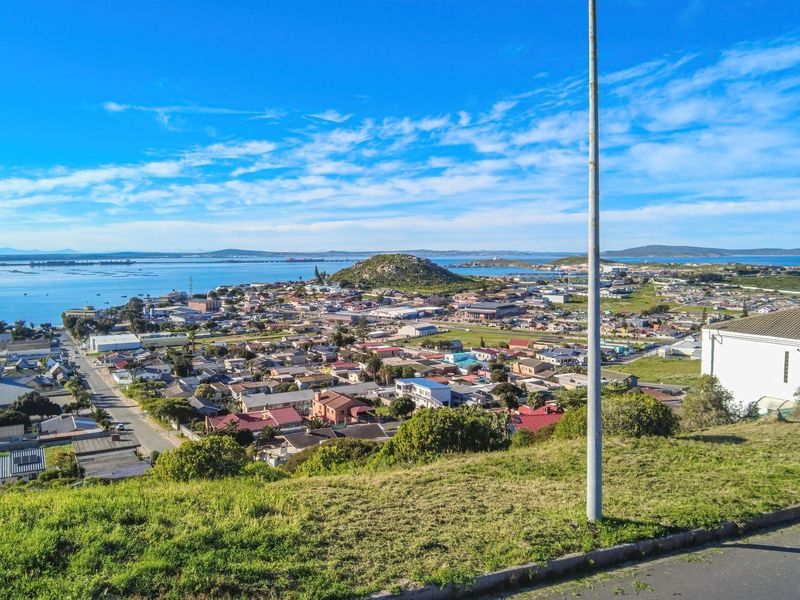 Elevated panoramic view overlooking the coastal town, surrounding landscape, and bay area, showcasing the property's scenic location.