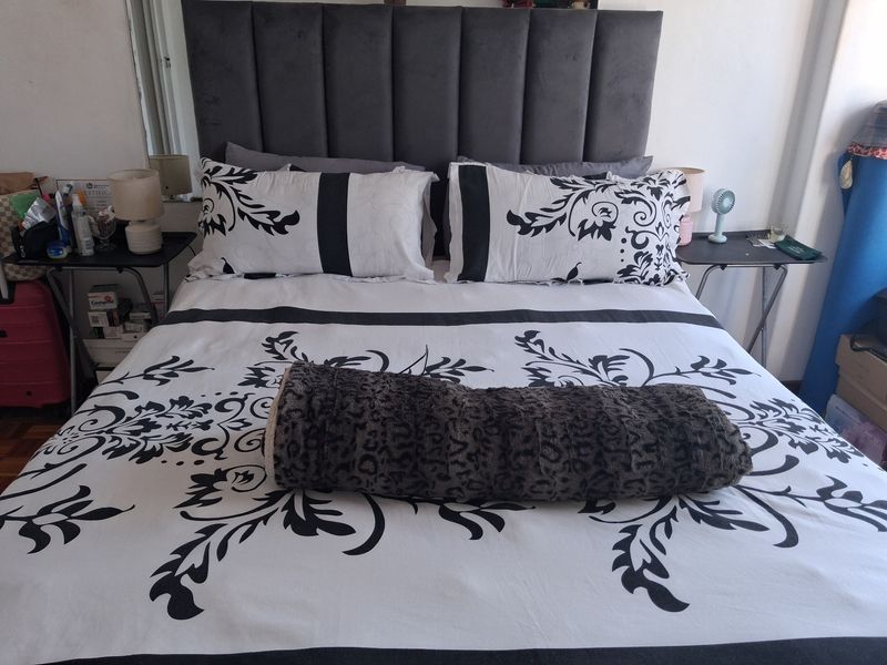 A bedroom featuring a dark upholstered headboard, providing a neutral foundation for the sleeping area.