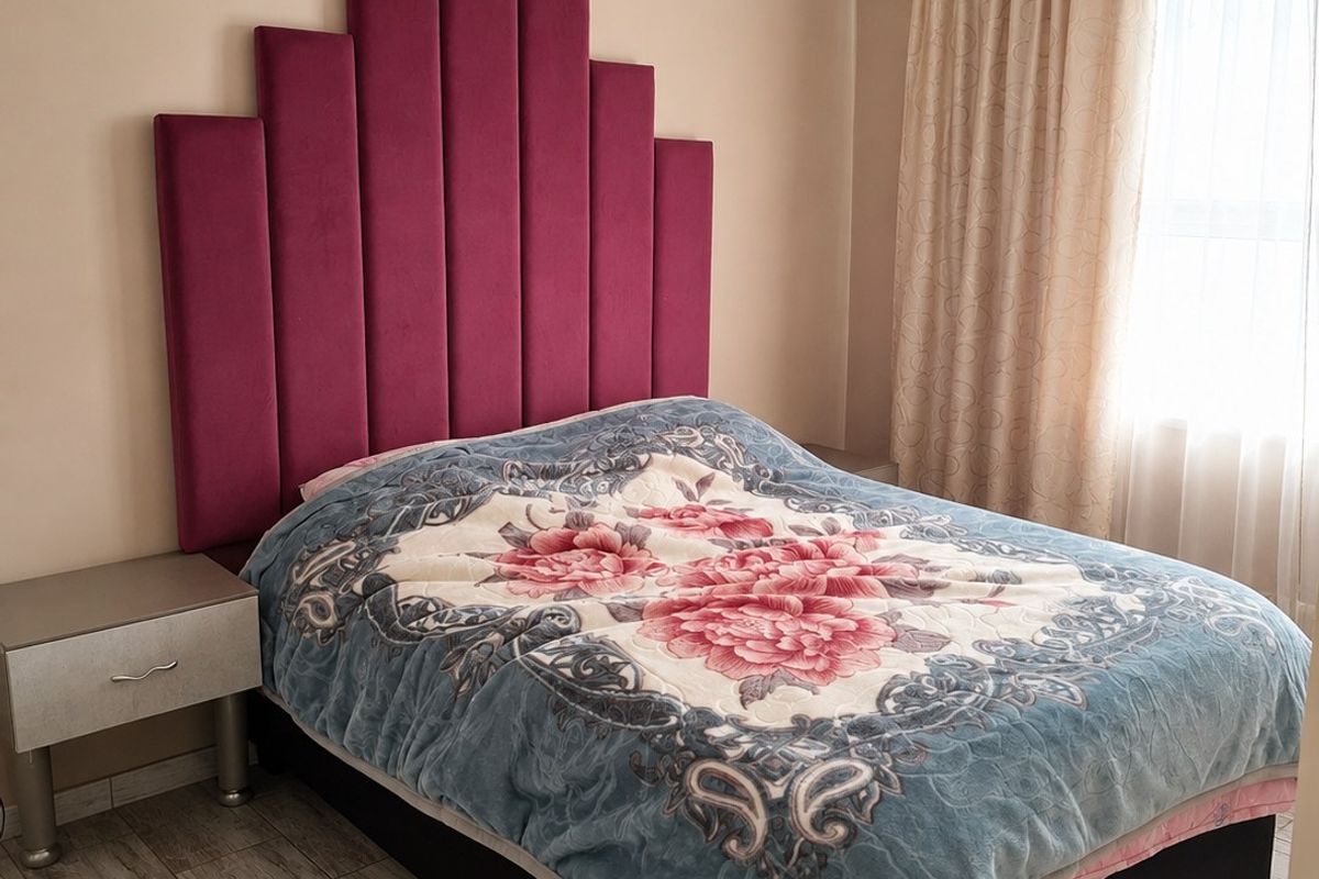 A well-maintained bedroom featuring tiled flooring, crown molding, and a wall-mounted split-system air conditioner.