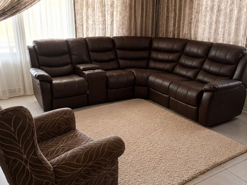 A comfortable living room featuring neutral tiled flooring and a recessed ceiling design, creating a bright and inviting space.
