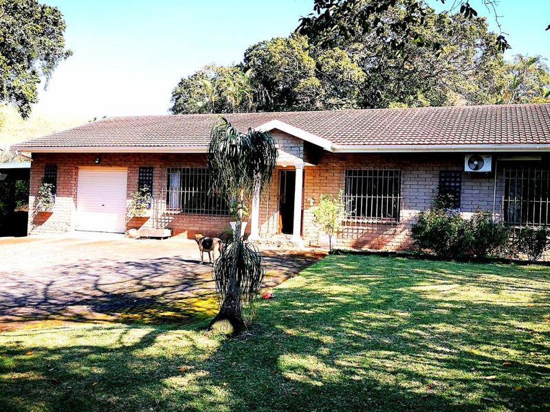 Front view of a single-story brick house featuring a tiled roof, paved driveway, and security bars on the windows.