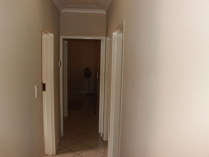 A functional hallway featuring tiled flooring and neutral wall finishes, providing access to multiple rooms within the home.