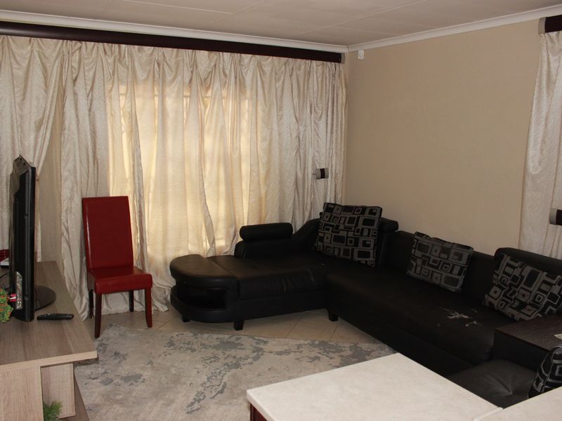 A living room featuring tiled flooring and neutral wall finishes, providing a functional space for relaxation.