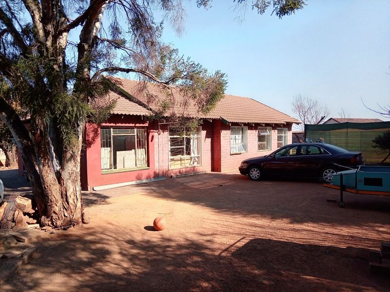 Front elevation of a single-story brick house featuring a tiled roof and multiple steel-framed windows in need of maintenance.