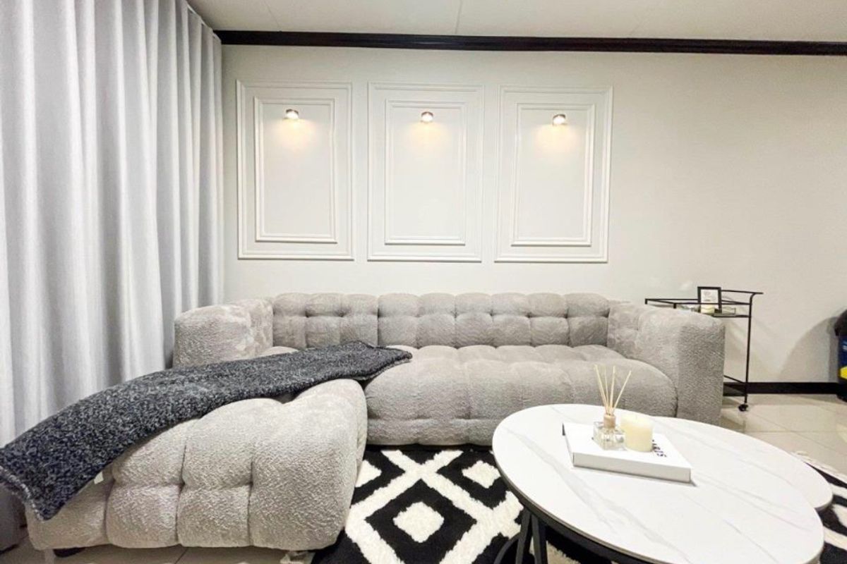 A well-maintained living room featuring decorative wall niches with integrated accent lighting and elegant crown molding.