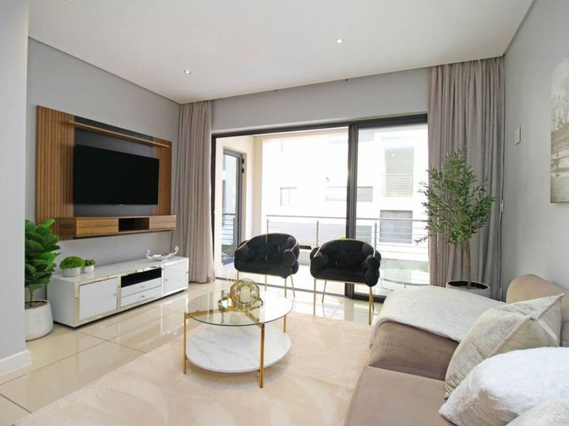 Modern living room featuring tiled flooring, recessed lighting, and a built-in media wall unit with direct access to a private balcony.