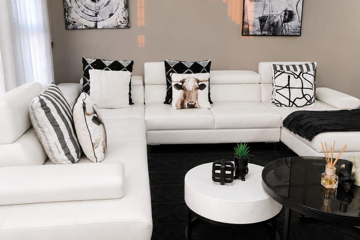 A well-maintained living room featuring neutral wall tones, crown molding, and tiled flooring, creating a clean and modern atmosphere.