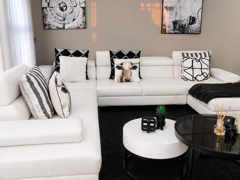 A well-maintained living room featuring neutral wall tones, crown molding, and tiled flooring, creating a clean and modern atmosphere.