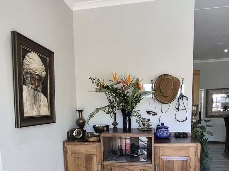 A well-maintained hallway featuring light-toned laminate flooring, recessed ceiling lighting, and decorative coving, providing a clean and neutral transition space.