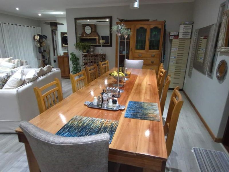 Spacious open-plan living and dining area featuring light-toned laminate flooring and recessed ceiling lighting, creating a functional and connected family space.