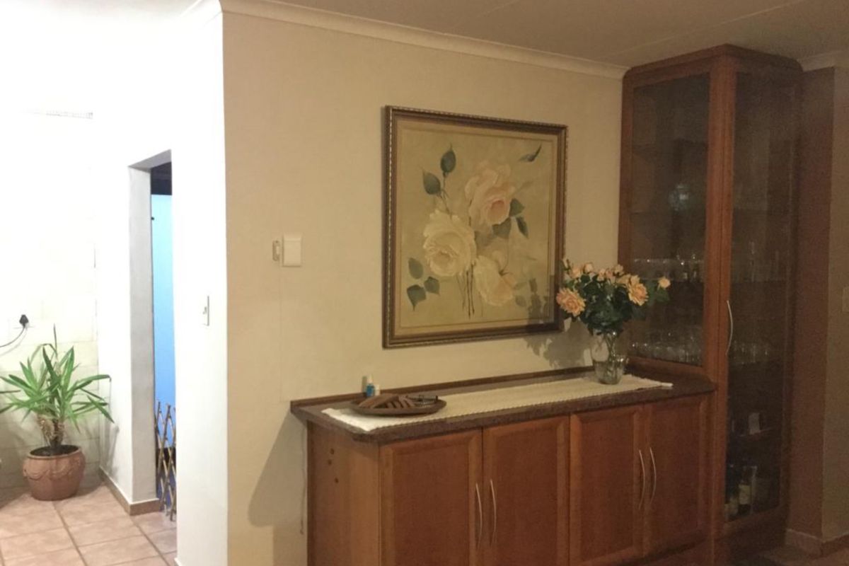 A living area featuring built-in wooden cabinetry and tiled flooring, providing a functional space with traditional finishes.