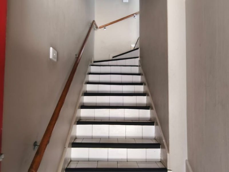 A functional interior staircase featuring tiled steps and a wooden handrail, providing access between levels within the apartment.