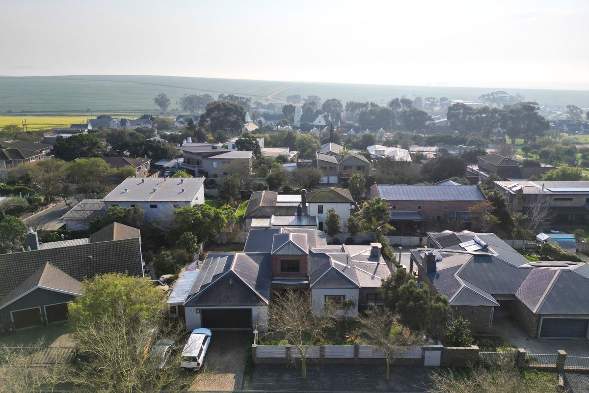 Aerial view of the property showing the roof structure, solar panel installation, driveway, and surrounding residential neighbourhood.