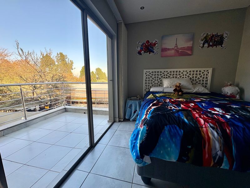 Bedroom featuring large sliding glass doors leading to a private balcony with metal balustrade, tiled flooring, and recessed ceiling lighting.