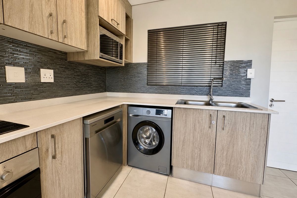 Modern kitchen featuring wood-look cabinetry, stone countertops, mosaic tile backsplash, and integrated appliances including an oven, hob, and microwave.