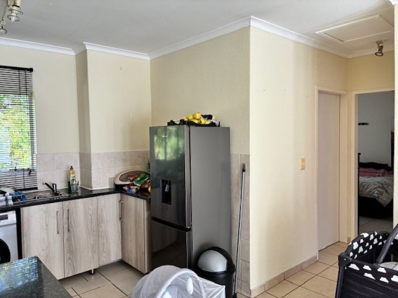 A functional kitchen featuring laminate cabinetry, granite countertops, tiled backsplash, and ceramic flooring, offering a practical layout for daily meal preparation.