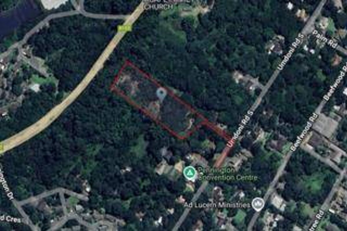 An aerial view showing the boundaries of the vacant residential land plot surrounded by established trees and local road infrastructure.