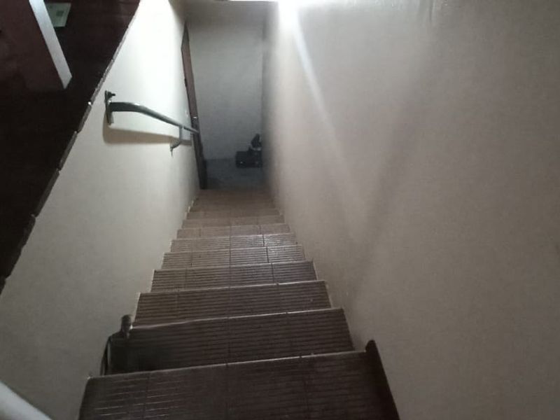 A view looking down a tiled staircase with a fixed handrail, connecting different levels of the townhouse.