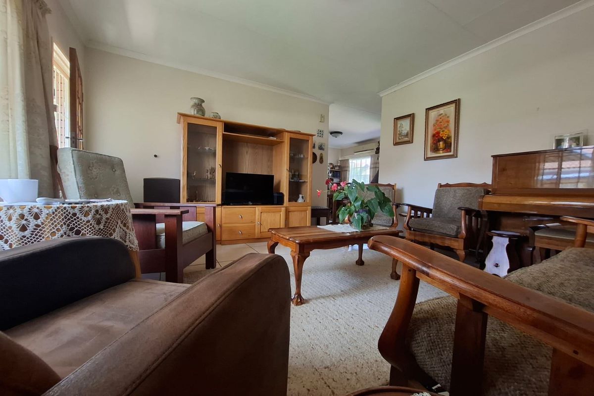 A spacious living room featuring neutral walls, coving, and tiled flooring, offering a comfortable and traditional layout for family relaxation.