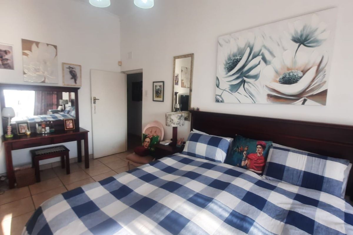 A spacious bedroom featuring tiled flooring and neutral wall finishes, providing a comfortable and functional sleeping area.