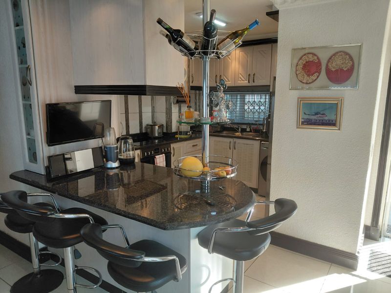 A functional kitchen featuring a granite breakfast bar, built-in cabinetry, and integrated appliances, offering a practical layout for daily cooking and dining.