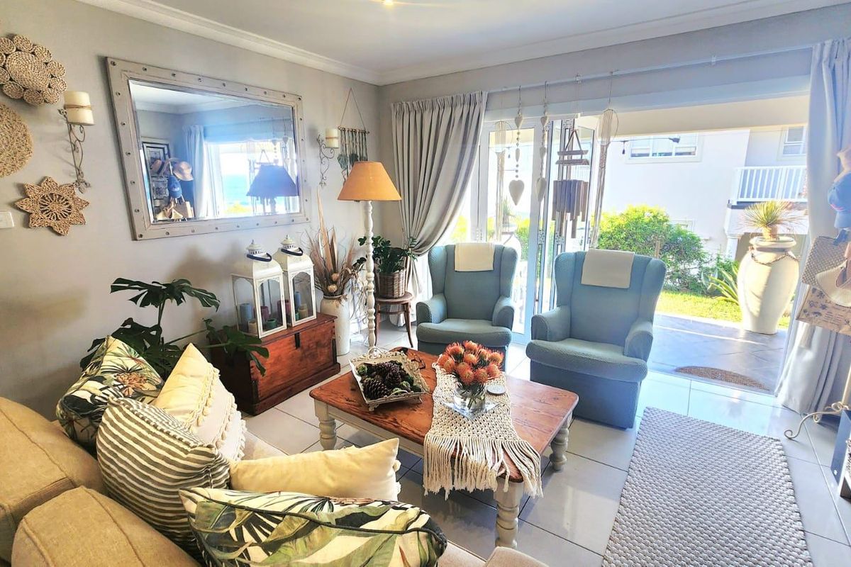A bright living room featuring tiled flooring and large sliding glass doors that provide seamless access to the outdoor patio area.