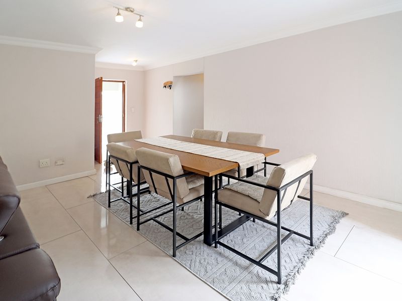 A bright and spacious dining area featuring neutral walls, tiled flooring, and coved cornicing, providing a clean and functional space for family meals.