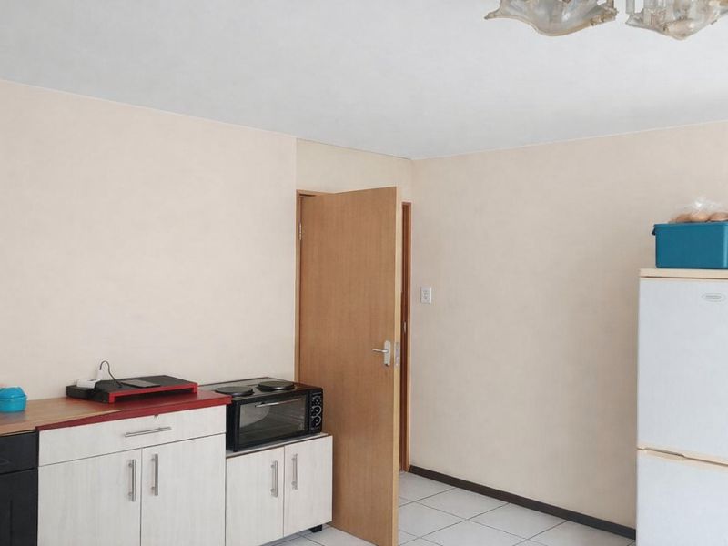 A functional kitchen area featuring built-in cabinetry, tiled flooring, and a standard door leading to an adjacent room.