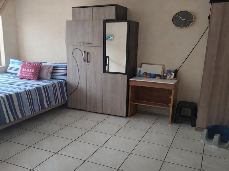 A bedroom featuring tiled flooring and neutral wall finishes, providing a functional living space.