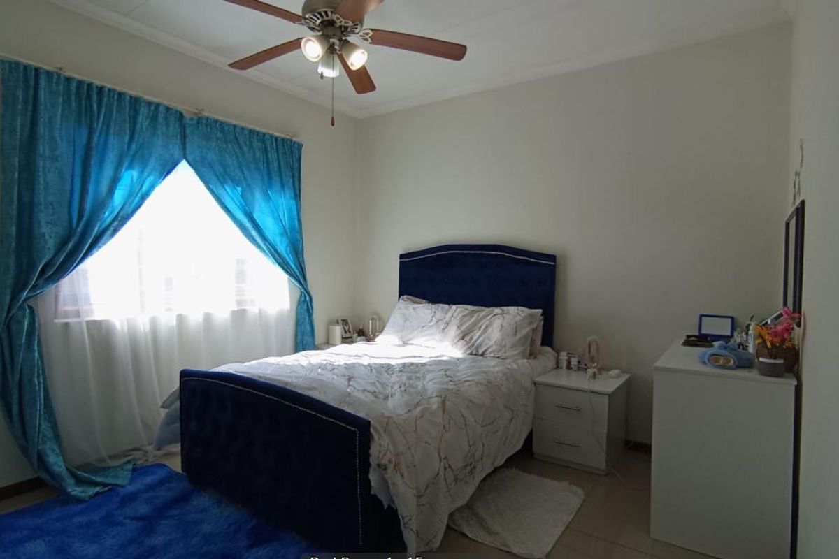 A standard bedroom featuring tiled flooring and a ceiling fan, providing a functional and comfortable living space.