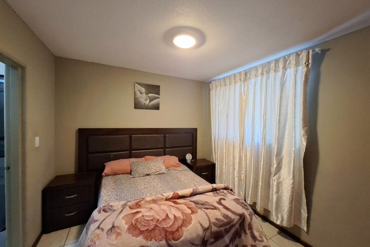 A functional bedroom featuring tiled flooring and a central flush mount ceiling light, providing a neutral base for personalization.
