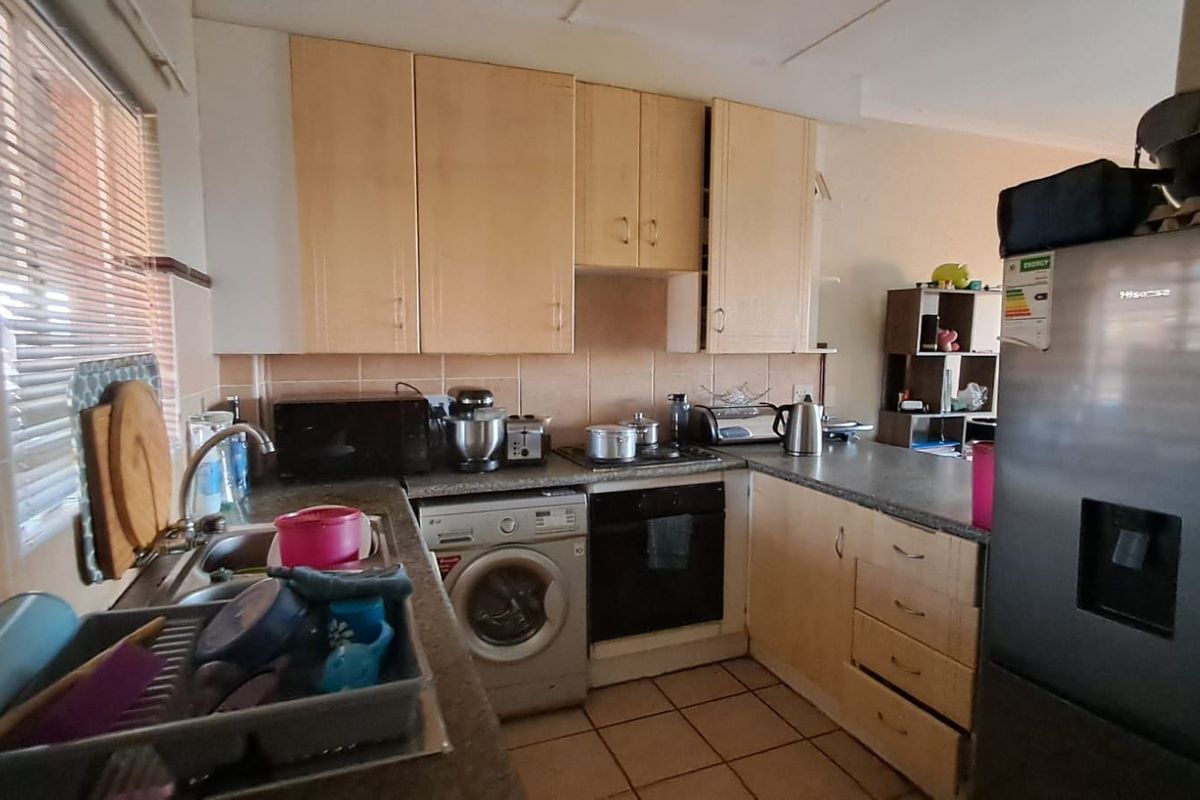 Functional kitchen featuring laminate cabinetry, tiled backsplash, built-in oven, hob, and tiled flooring, providing a practical workspace for daily cooking needs.