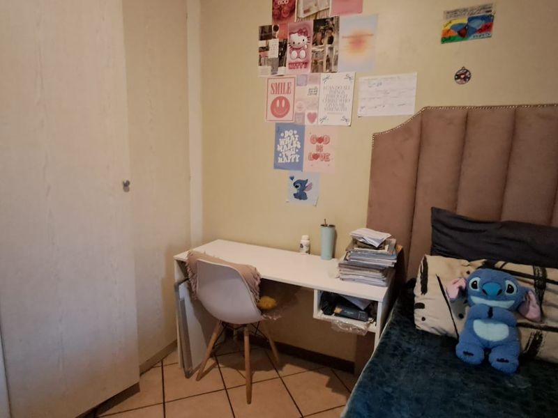 A bedroom featuring tiled flooring and a built-in cupboard, providing functional storage space.