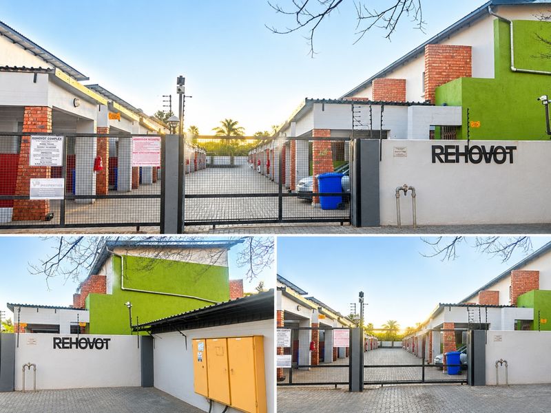 Front entrance view of the Rehovot complex featuring a secure gated driveway, brick pillar detailing, and perimeter electric fencing.