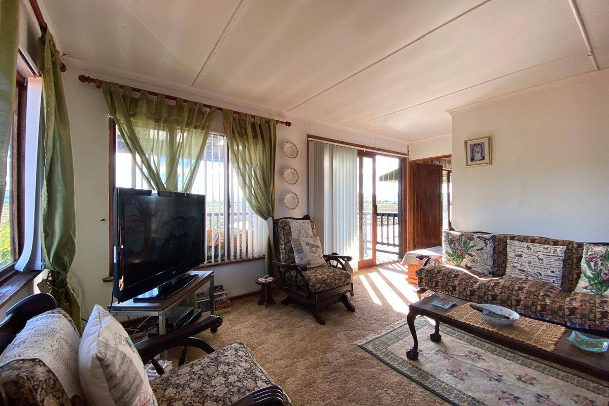 A living room featuring large windows and a sliding glass door that provides natural light and access to the exterior.