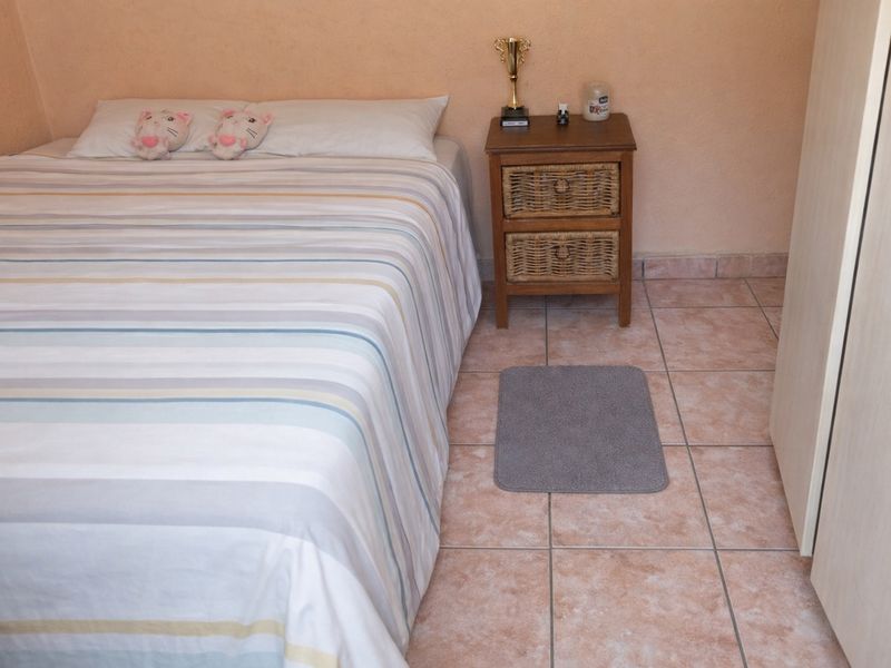 A bedroom featuring tiled flooring and built-in wardrobe storage.