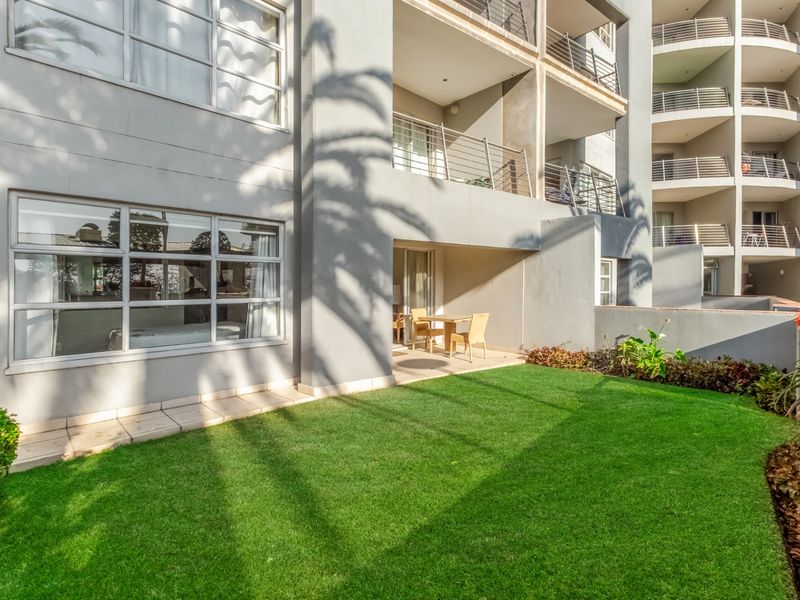 Ground floor apartment featuring a private garden area, covered patio, and large windows providing natural light to the interior living space.
