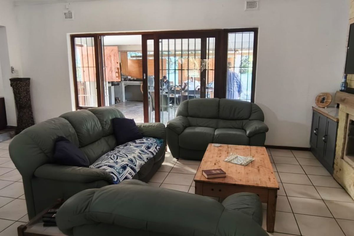 Spacious living room featuring a stone-clad fireplace, tiled flooring, and large sliding doors providing seamless access to the outdoor patio area.