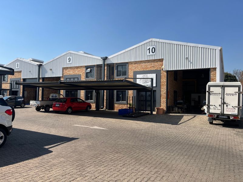 Exterior view of industrial units 8, 9, and 10, featuring brick facades, corrugated metal roofing, and covered parking bays.