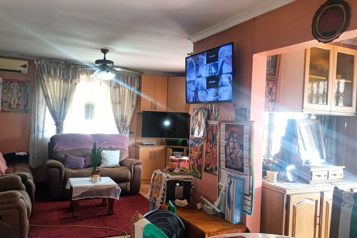 A living room featuring built-in cabinetry, a ceiling fan, and an air conditioning unit, providing a functional and lived-in space.