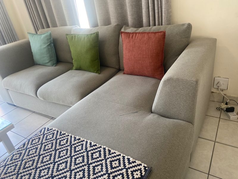 A living room area featuring neutral tiled flooring and standard electrical wall outlets.