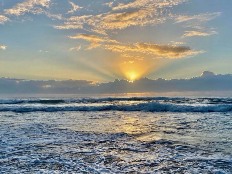 A scenic view of the ocean at sunrise, showcasing the natural beauty and coastal location of the property.
