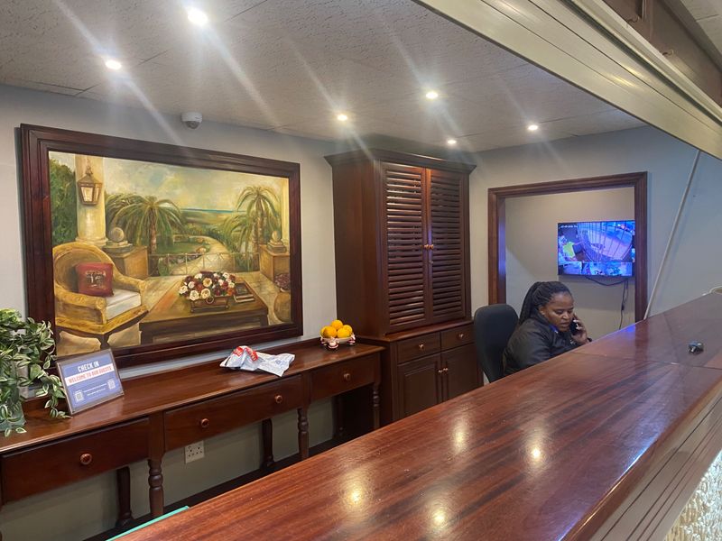 A professional reception area featuring a large wooden service counter, built-in storage cabinetry, and integrated security monitoring systems.