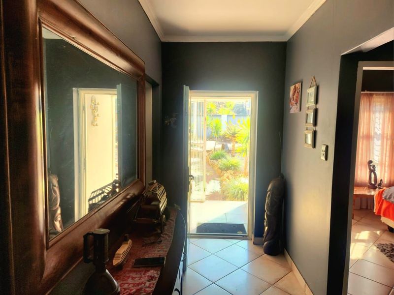 An entrance hallway featuring tiled flooring and direct access to the exterior garden area.