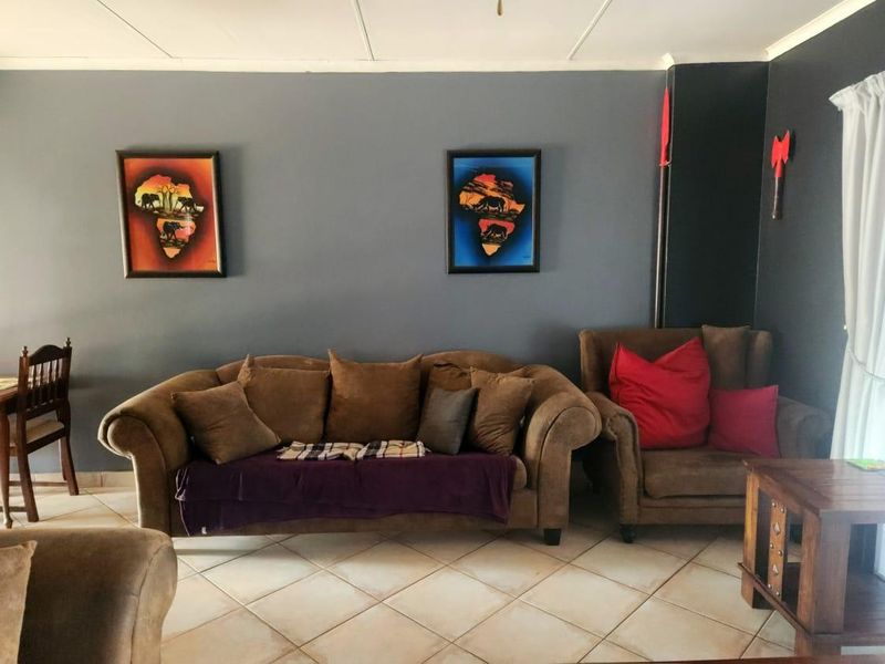 A living room area featuring tiled flooring and dark grey painted walls, providing a neutral base for interior design.