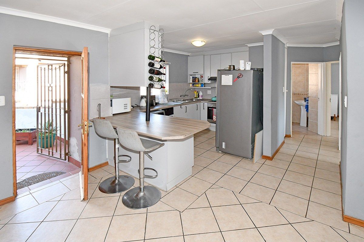 Functional kitchen featuring built-in cabinetry, a breakfast bar, and tiled flooring, with direct access to an outdoor patio area.