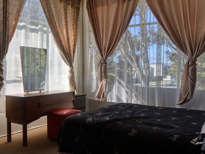 A bedroom featuring large windows that provide ample natural light and views of the surrounding area.