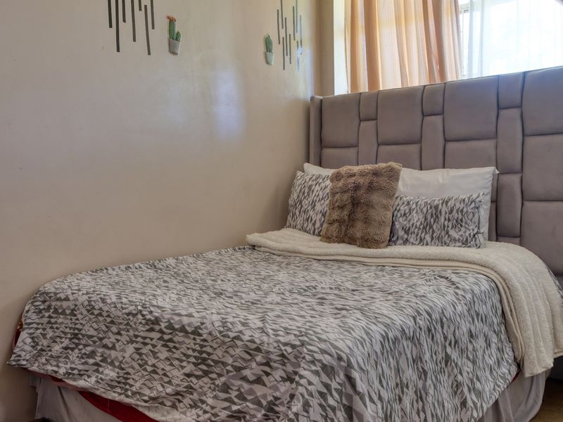 A bedroom featuring a neutral wall finish and a window with curtains.