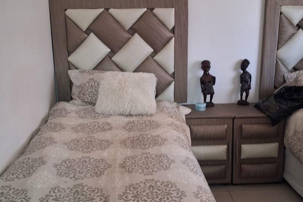 A bedroom featuring built-in headboards and matching bedside cabinetry.